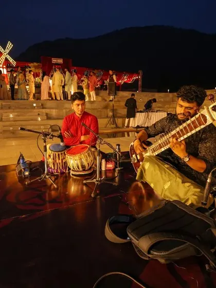 The reception for Sonam and Ross was a grand affair with a stunning red windmill and live musicians. This wide shot shows the scale and creativity we bring to destination weddings.