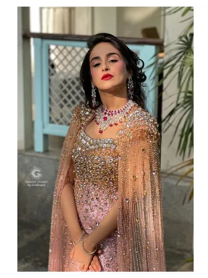 A full portrait from the Hollywood glamour shoot. The makeup is bold and confident, with a striking red lip that perfectly complements the sparkling rose gold gown.