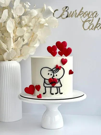 A minimalist and modern love themed cake. The simple stick figure couple holding a heart is a cute and stylish way to celebrate an anniversary or just because.