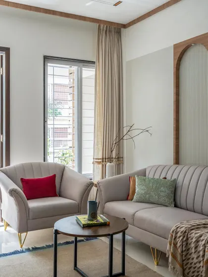 A minimalist living room with soft, neutral-toned furniture and clean lines. The design emphasizes comfort and simplicity, creating a calm and inviting space for relaxation.
