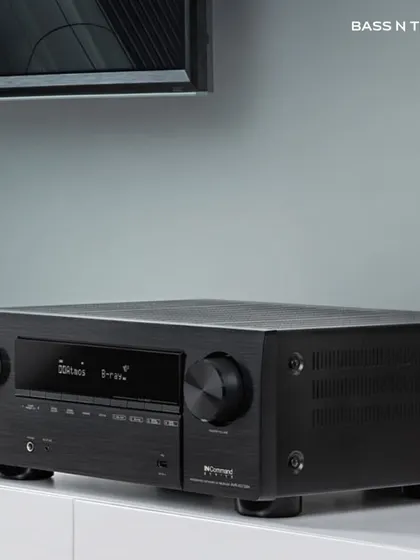 A Denon AV receiver sitting elegantly in a home entertainment setup. We choose receivers that not only deliver thrilling surround sound but also fit the aesthetic of your room.