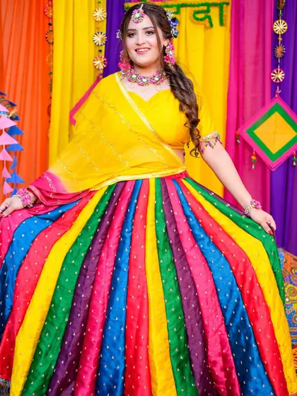 A full-length shot of the bride in her stunning multi-colored lehenga, looking absolutely radiant for her Mehendi function.