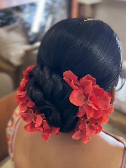 A close up of the vibrant red floral bun, showing the fullness of the flowers.