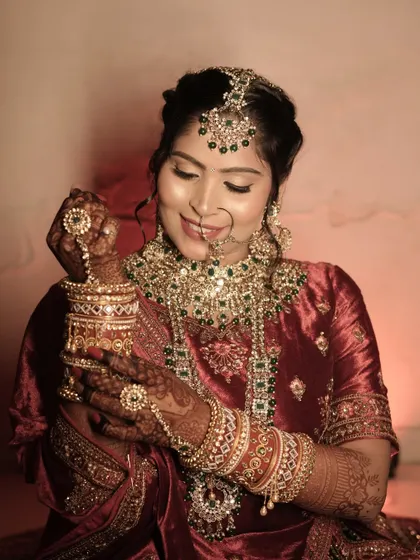 A beautiful candid shot of the bride admiring her bangles. The soft lighting highlights the glowing skin and detailed eye makeup I created for her.