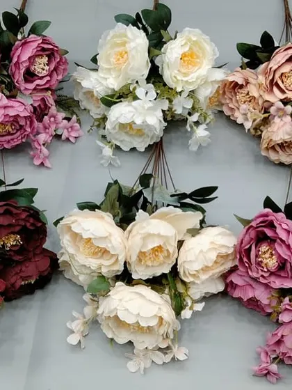 A collection of large, open artificial peony bunches in various shades of pink and white.