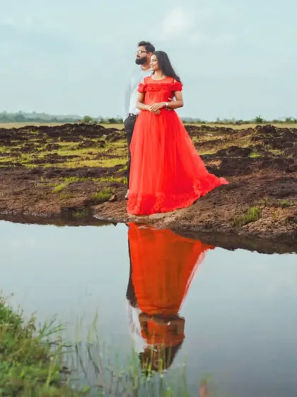 A beautiful reflection shot of a couple by the water. The vibrant red of her gown creates a stunning visual, making for a memorable pre-wedding picture.