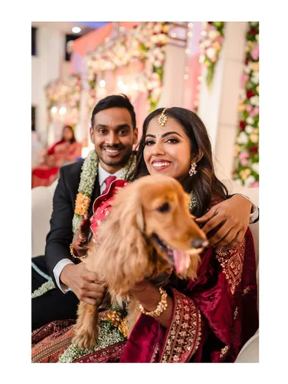 A fun and heartwarming photo of the couple with their furry friend at the reception.