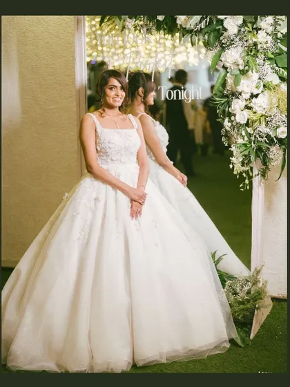 A beautiful portrait of the bride by a mirror adorned with flowers. The reflection adds depth to the image, creating an elegant and timeless bridal shot.