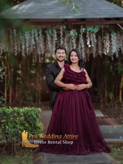 A close-up of a couple, showing the detailed texture of the ruffled maroon gown alongside a simple black suit. This pairing is ideal for romantic and intimate portraits.