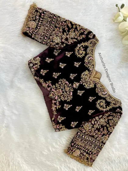 A masterpiece in velvet. This deep wine-colored blouse is covered in royal zardozi embroidery, perfect for a grand reception look.