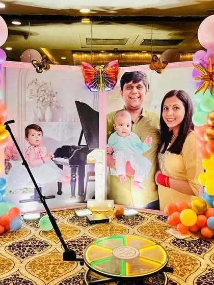 A personalized photo backdrop at Veeha's butterfly-themed party, flanked by colorful balloon columns.