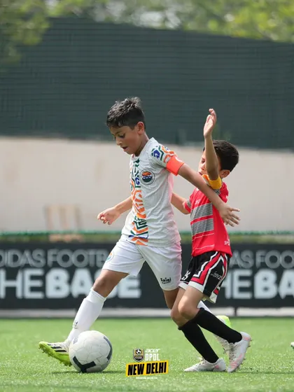 Shielding the ball under pressure. This player shows the strength and ball control skills that are essential for maintaining possession in tight spaces.