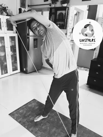 Using a resistance rope, this client performs a side bend, stretching the obliques and improving spinal mobility.