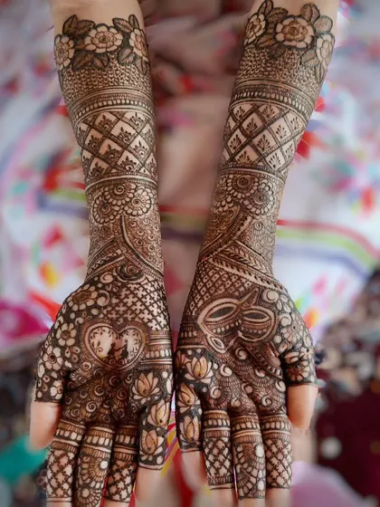 Love is in the details. This bridal design features a heart-shaped frame for the couple's silhouette on one hand and a traditional kalash on the other, symbolizing the union of love and tradition.