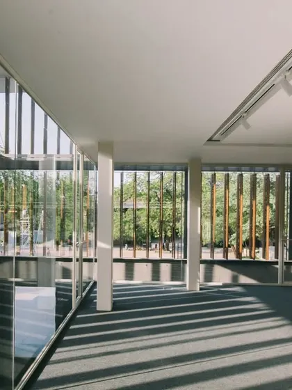 An upper-level reading area in the Lilavati Lalbhai Library offers views out to the campus through a screen of wooden louvers. This space provides a quiet zone for study while maintaining a connection to the surrounding environment.