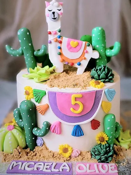 This is a no-drama-llama cake! A super fun and colorful llama-themed cake with edible cacti and festive bunting for a 5th birthday.