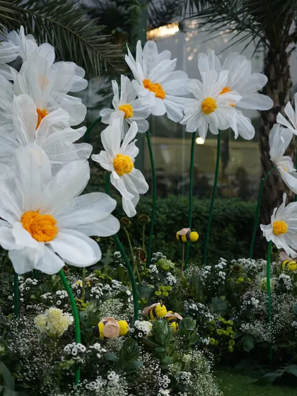 A close-up of the giant daisy installation, showing the delicate, handmade petals and the small, happy bees buzzing amongst the flowers. It’s these thoughtful details that bring our themes to life.