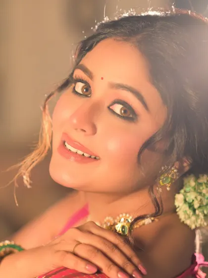 A bright and cheerful close-up portrait. The model's engaging smile and the warm, glowing light make this a very inviting image.