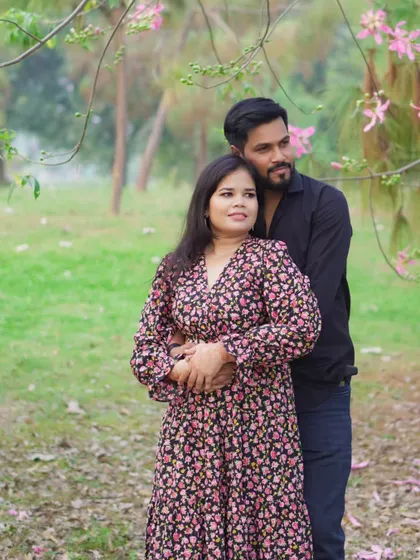 A tender moment captured during a couple's pre-wedding shoot, with the groom embracing the bride-to-be from behind in a serene, natural environment.