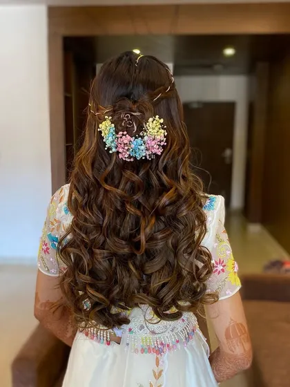 A beautiful shot of Gunjan's hairstyle, adorned with colorful flowers to match her outfit. A perfect look for a Mehendi or Haldi ceremony.