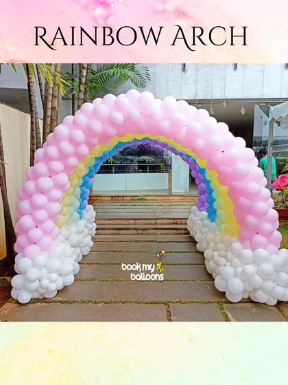 This beautiful rainbow balloon arch creates a cheerful and welcoming entrance for any party. The pastel colors and fluffy white balloon clouds at the base make it a perfect photo opportunity for guests as they arrive.