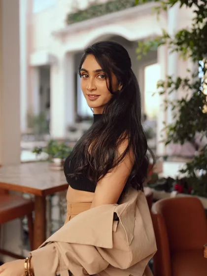 A profile view that showcases the simple, elegant half-up hairstyle that complements the chic outfit.