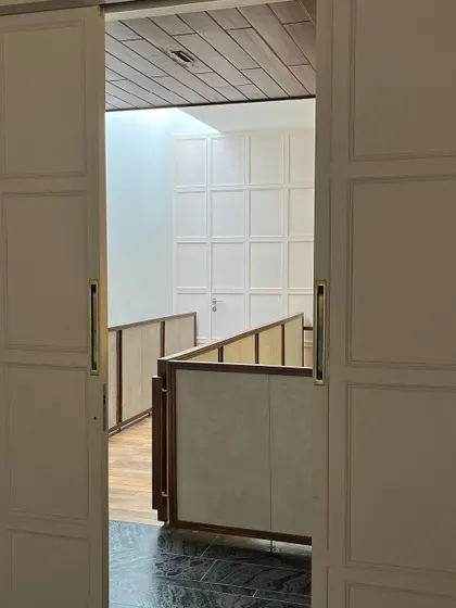 A view of the skylit bridge through sliding paneled doors. This design allows the upstairs area to be opened up or closed off, providing flexibility and privacy.