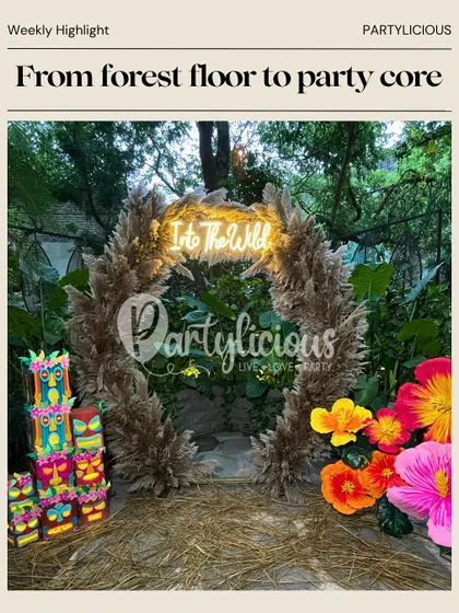 From forest floor to party core. Our 'Into the Wild' tribal-themed setup was a highlight, featuring a neon sign, pampas grass arch, and colorful tiki-style props.