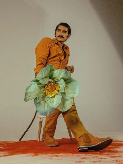 A seated pose from 'Flower Power', using a simple stool as a prop.