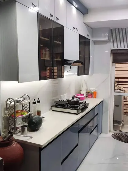 This wider view of the Paras Tieria kitchen shows the dual-tone cabinet design and the seamless integration of the workspace with the rest of the home.