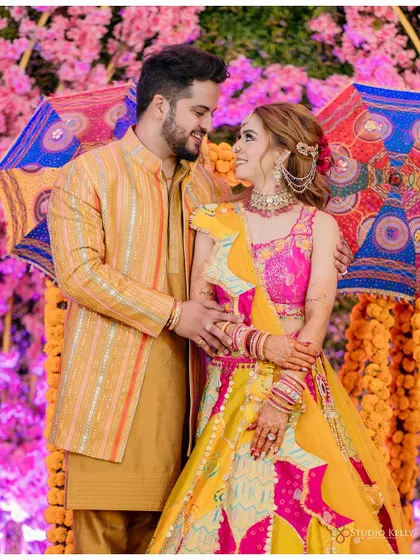 A happy and candid portrait of the couple at their vibrant Mehendi ceremony.
