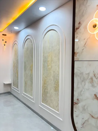 The finished wall panel, illuminated by warm cove lighting from the false ceiling, which enhances the texture and makes it a focal point.