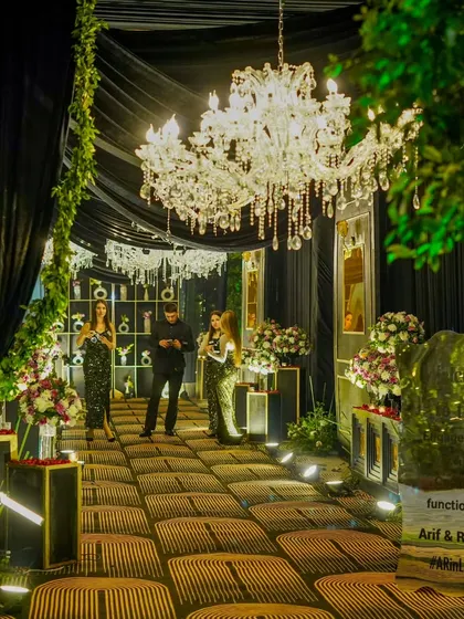 Guests mingling at the entrance, which features a custom-lit sign and a photo display wall, creating an interactive and personalized experience from the moment they arrive.