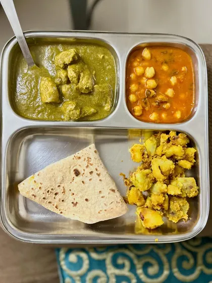 A double-protein meal with chapati, chicken palak, chana masala, and sautéed potato.