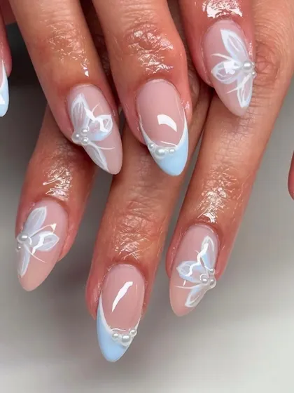 Light and ethereal. This lovely set features hand-painted white butterflies with delicate pearl bodies, paired with a soft baby blue French tip.