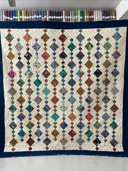 A gorgeous "Chandelier" quilt, where strings of diamond-shaped fabric pieces cascade down the surface.