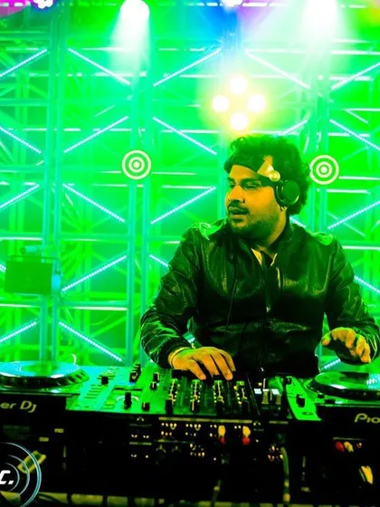 Focused at the console against a vibrant green lighting setup. Every performance is a chance to be better than the last.