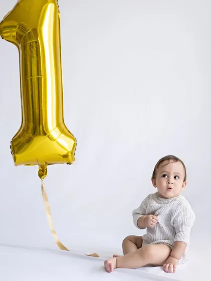 "Wait... I'm ONE already?!" This little one looks so surprised and cute next to his giant number one balloon.