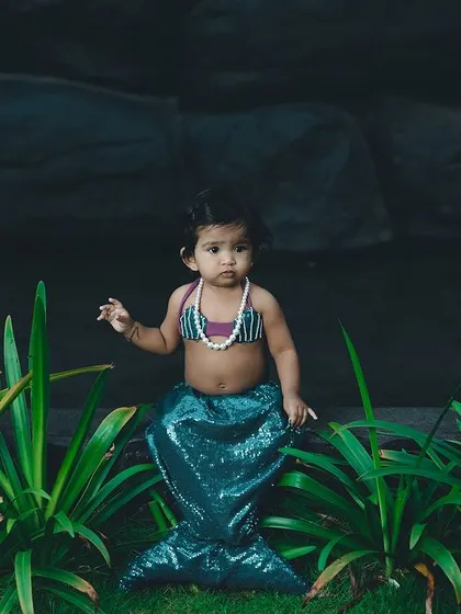 A mysterious little mermaid sitting by the water's edge. We use creative lighting to set a magical mood.