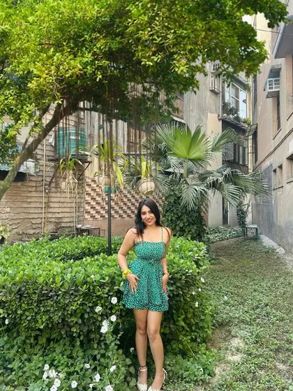 A full, front-facing shot of the green romper. This clearly shows the design and fit of the playful outfit.
