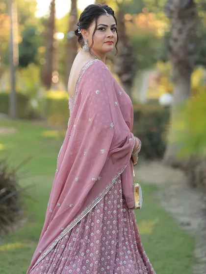 A beautiful profile shot, showing off her elegant updo and the back of her lehenga.