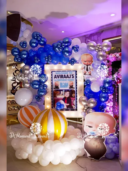 A close-up of the party entrance, highlighting the illuminated welcome sign and the playful arrangement of balloons and Boss Baby cutouts.