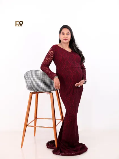 A full-length portrait of the mom-to-be in a deep red lace gown. This modern yet glamorous look is perfect for making a statement.