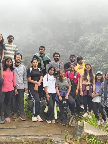 A group photo on a rocky outcrop, with the misty forest behind them.
