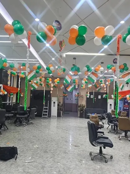 A spacious office floor decorated with tricolor balloon bunches and small Indian flags hanging from the ceiling. This setup fills a large area without obstructing movement, making it perfect for open-plan offices.