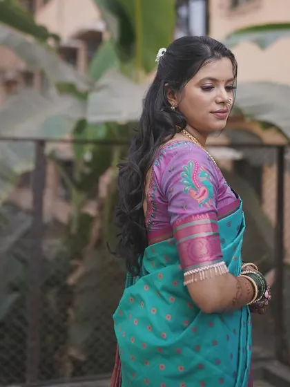 Another view of the bride's beautiful saree and hairstyle. The makeup remains understated to let the traditional attire shine.