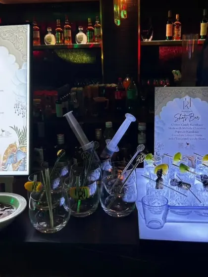 This setup features a custom-designed, illuminated menu alongside our unique 'Shots Bar'. The syringe-style shot dispensers add a fun, quirky element that gets guests talking.