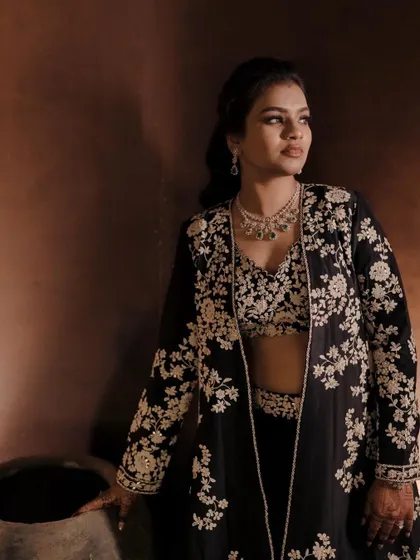 A stunning portrait of the bride in a chic, black embroidered outfit, posing with an air of elegance and confidence before her evening event.