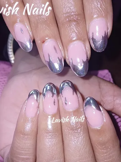 A creative take on a French manicure with a dripping silver chrome effect on oval nails.