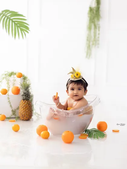 A wider shot of the fruit bath setup, showing the pineapple and other decorative elements that complete the tropical theme.